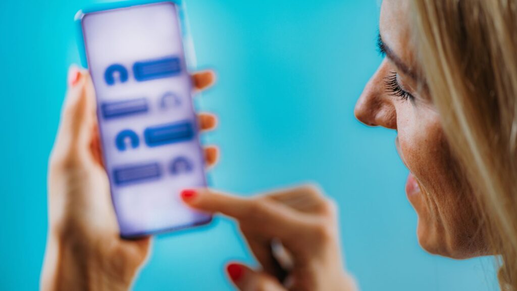 Imagem de uma mulher satisfeita enquanto interage com chatbots em seu celular.