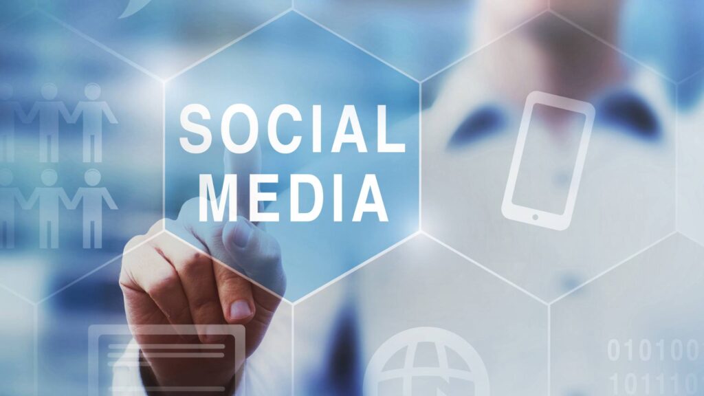 Imagem de uma tela digital escrita Social Media sendo tocada por um homem